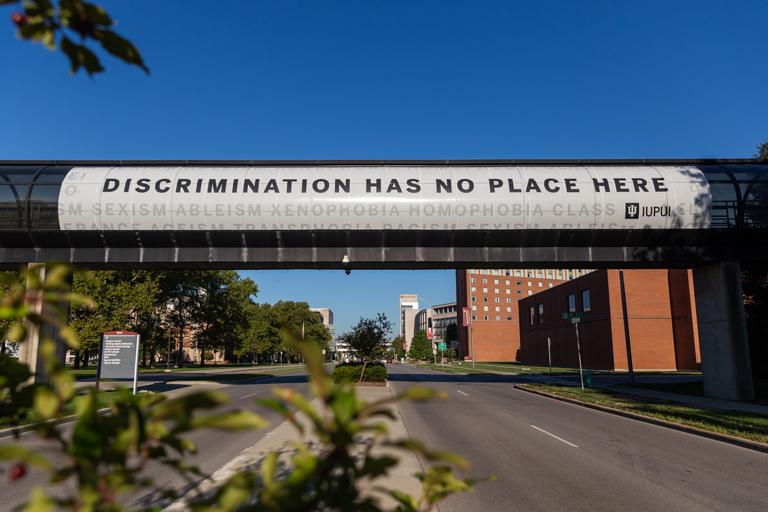Road overpass on the IUPUI campus painted with the words, Discrimination has no place here.